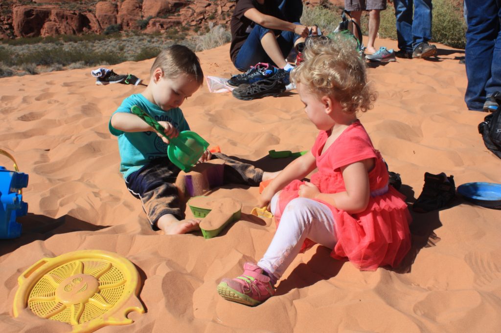 Kids playing in the snow canyon sand dunes.