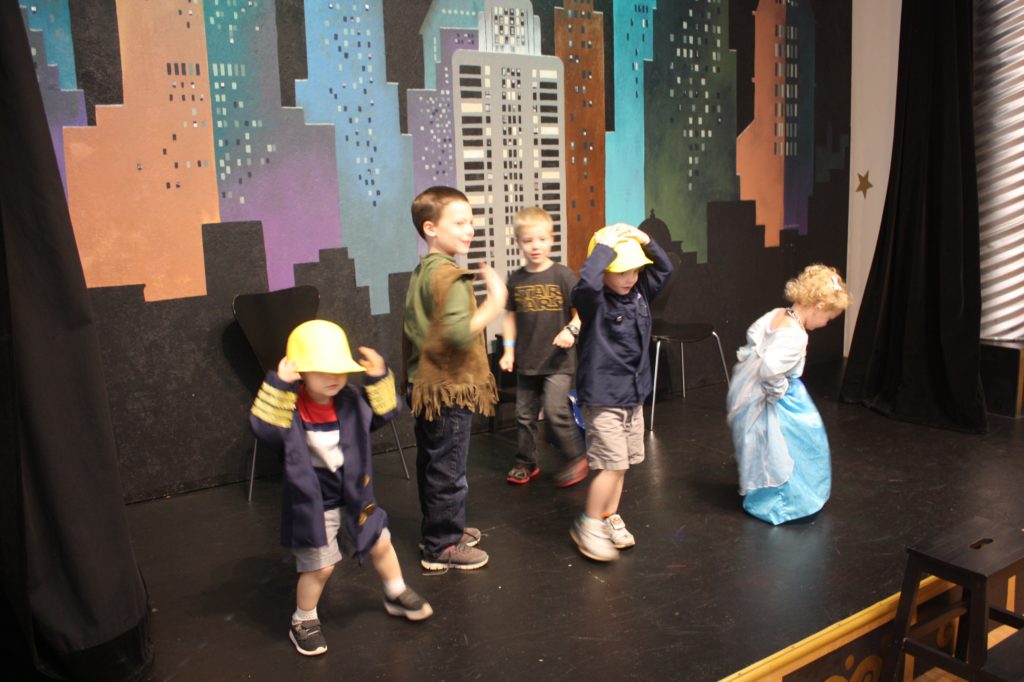 children on a stage at the museum