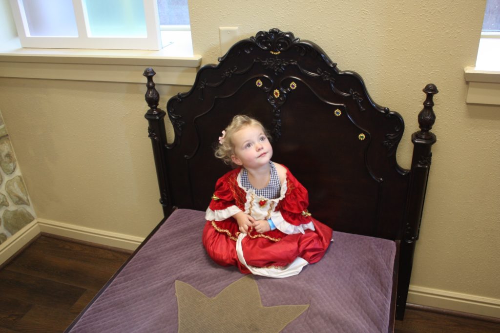 A little girl on the princess bed in the museum