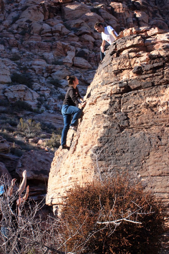 Girl climber going up a steep rock face