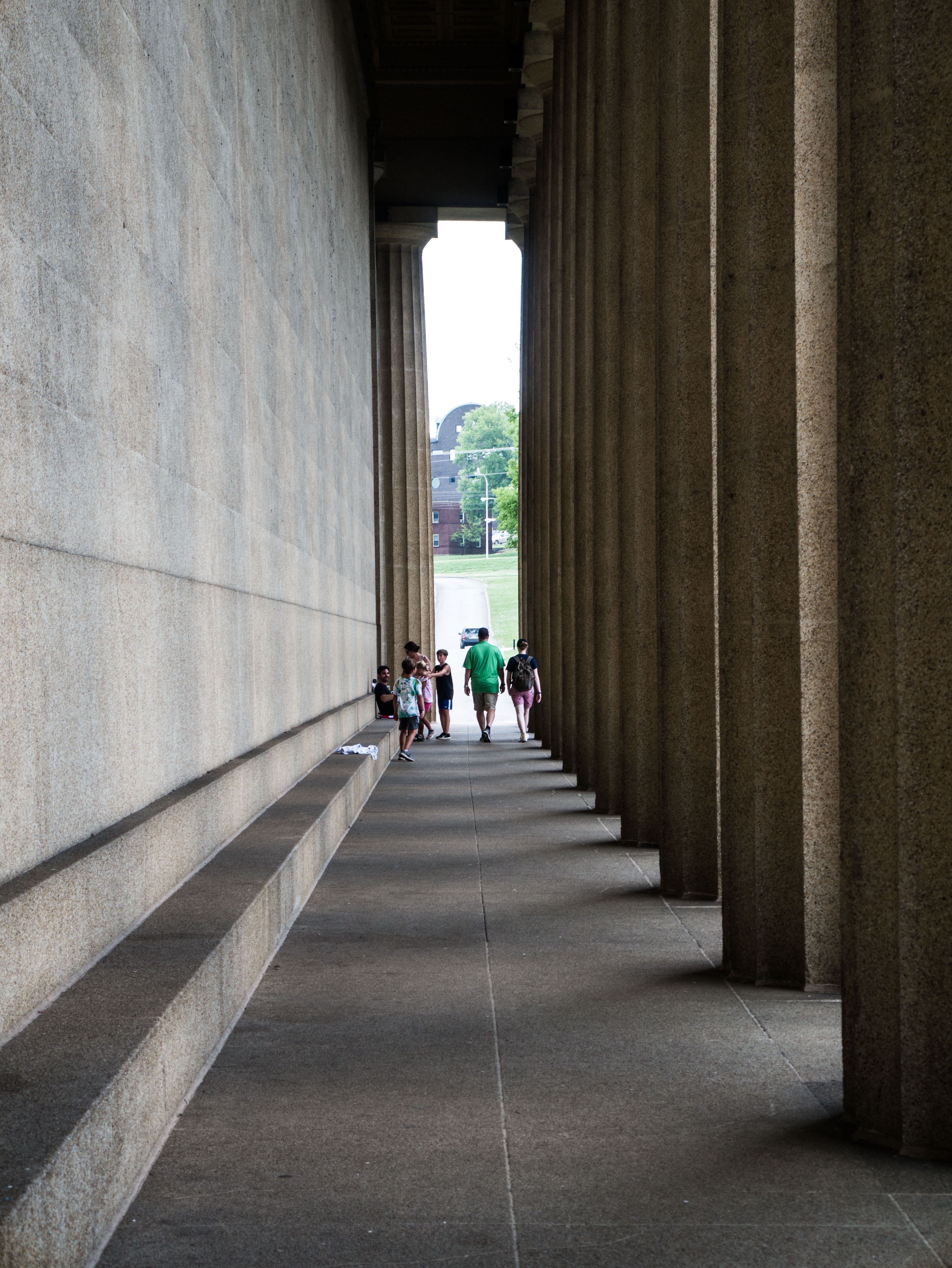 People walking down the colonnade at the Nashville Parthenon